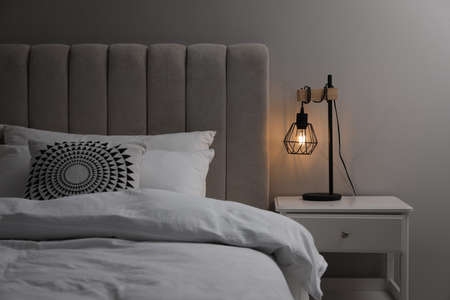 Stylish lamp on bedside table indoors. bedroom interior elementsの写真素材