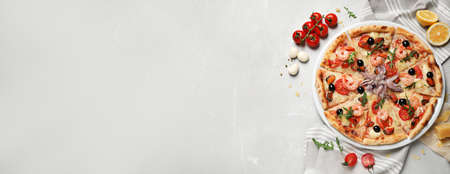 Tasty seafood pizza and ingredients on light gray marble table, flat lay with space for text. banner designの写真素材