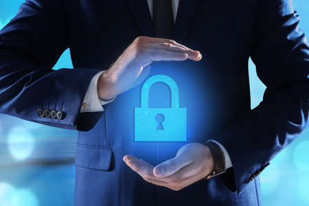 Cyber security concept. Man holding virtual icon of padlock on color background, closeupの写真素材