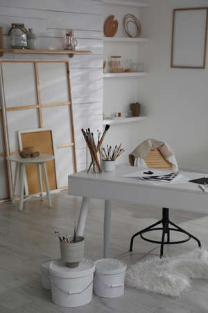 Modern studio interior with artist's workplace and art suppliesの写真素材