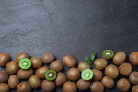 Fresh ripe kiwis on black table, flat lay. Space for textの写真素材