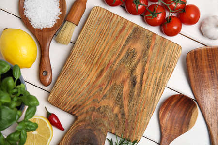 Flat lay composition with cooking utensils and fresh ingredients on white wooden tableの写真素材