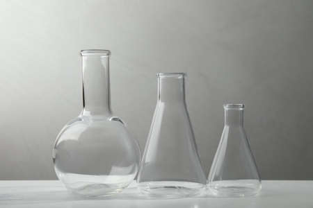 Set of laboratory glassware on white table against gray backgroundの写真素材