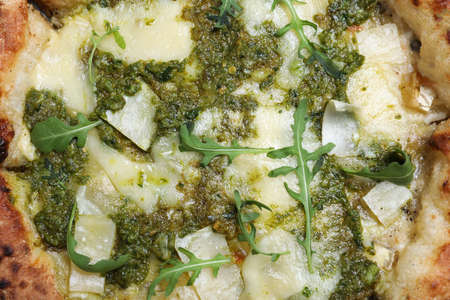 Delicious pizza with pesto, cheese and arugula as background, top viewの写真素材