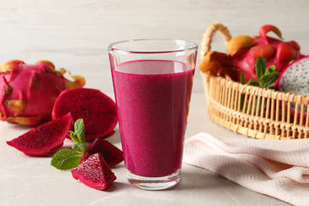 Delicious pitahaya smoothie and fresh fruits on light gray tableの写真素材