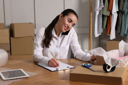 Seller talking on phone while working in office. online store