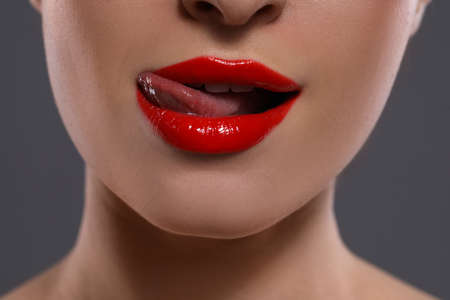Young woman with red lips makeup on gray background, closeupの写真素材