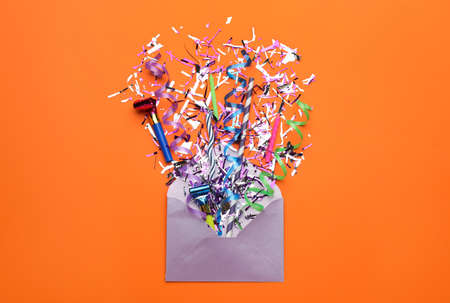 Beautiful flat lay composition with envelope and festive items on orange background. Surprise party...