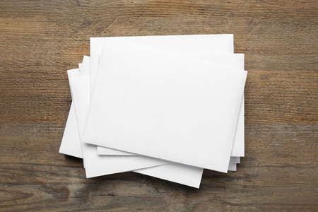 Stack of letters on wooden table, top view