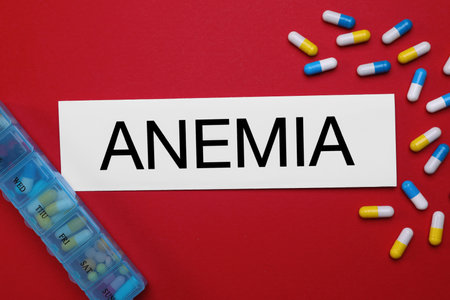 Card with word Anemia and pills on red background, flat layの写真素材