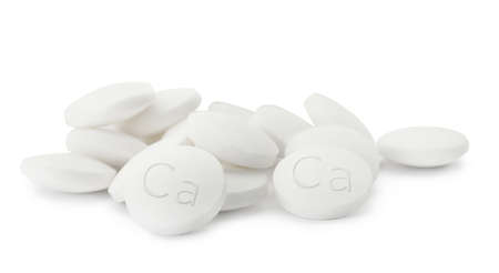 Pile of calcium supplement pills on white background