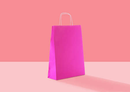 Pink paper bag on color background. Mockup for designの写真素材