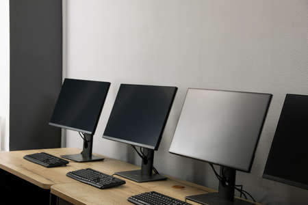 open office interior. Modern workplaces with computers near light gray wall