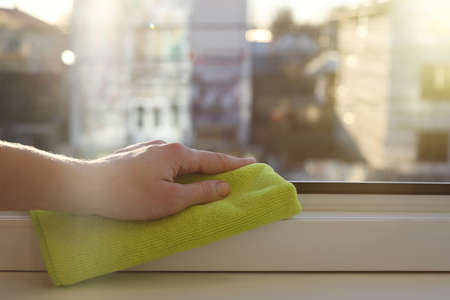 Woman cleaning window frame with rag at home, closeupの写真素材