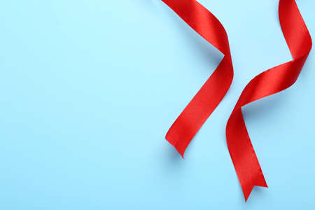 Beautiful red ribbons on light background, flat lay. Space for textの写真素材
