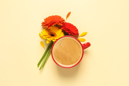 Beautiful colorful gerbera flowers, petals and cup of coffee on beige background, flat layの写真素材