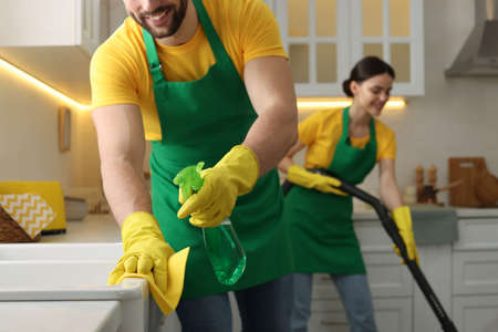 Professional janitors working in kitchen, closeup. cleaning service