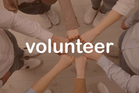 Group of volunteers putting hands together indoors, top viewの写真素材