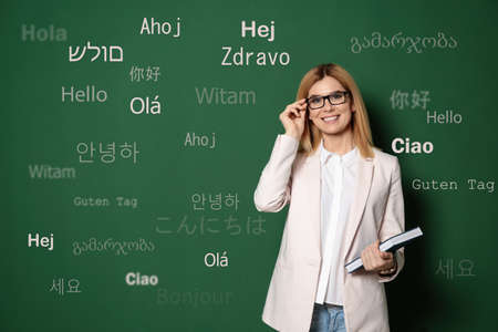 Portrait of happy translator and greeting words in different foreign languages on green background