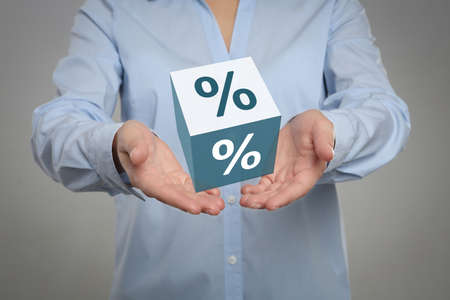 Woman showing virtual cube with percent sign on light gray background, closeup. discount conceptの写真素材