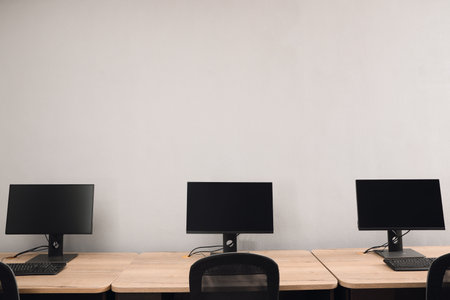 open office interior. Modern workplaces with computers near light gray wall