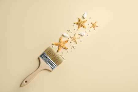 Brush painting with sea stars, pearls and shells on beige background, flat lay. creative conceptの写真素材