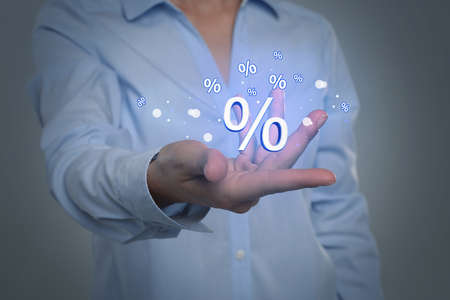 Woman showing virtual percent sign on light gray background, closeup. discount concept