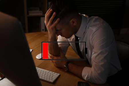 Illustration of discharged battery and tired man at workplace in office. extreme fatigue