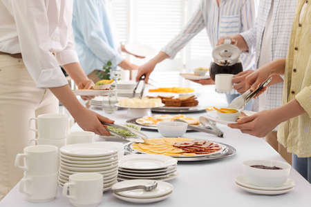 People taking food and pouring coffee during breakfast, closeup. buffet serviceの写真素材