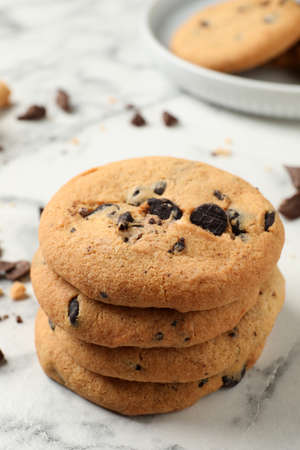 Delicious chocolate chip cookies on white marble table