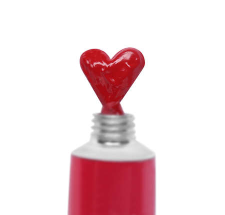 Red paint squeezed in shape of heart from tube on white background, top view