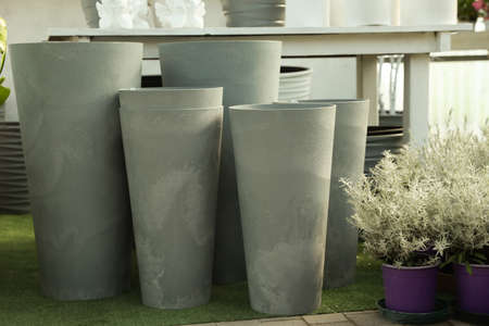 Large gray flowerpots and beautiful plants in garden centerの写真素材