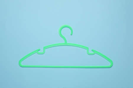 Empty clothes hanger on light blue background, top viewの写真素材