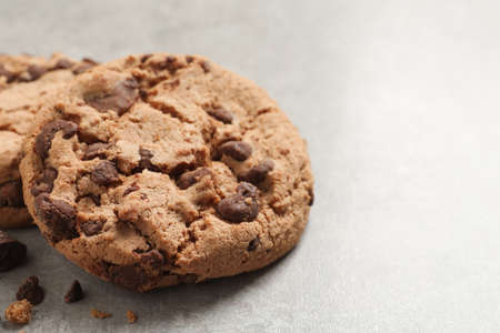 Delicious chocolate chip cookies on gray table, closeup. Space for text