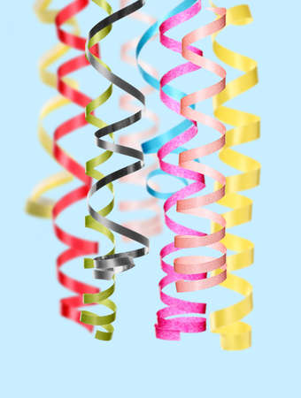 Many serpentine streamers on pale light blue background. party decorの写真素材