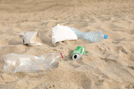 Different garbage scattered on sand. recycling problemの写真素材