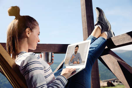 Woman talking with handsome man using video chat on laptop outdoors , closeup. Online datingの写真素材