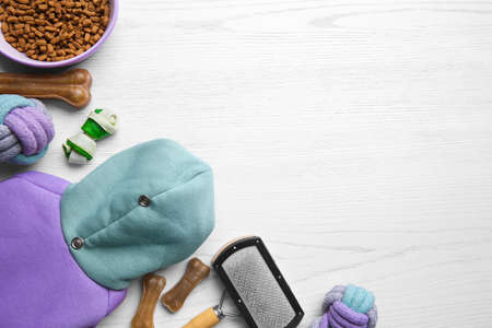Flat lay composition with dog clothes, food and accessories on white wooden table. Space for textの写真素材