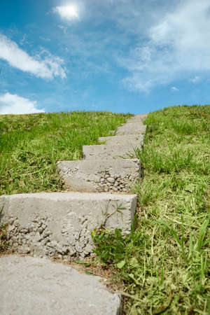 Outdoor concrete staircase up to hill, low angle view