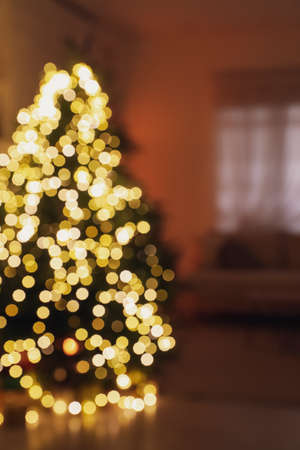 Blurred view of living room interior with decorated Christmas treeの写真素材