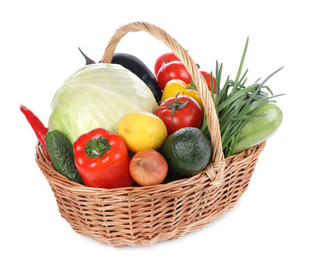Fresh ripe fruits and vegetables in wicker basket on white backgroundの写真素材