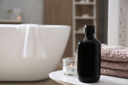 Bottle of shower gel and fresh towels on white table in bathroom. Space for textの写真素材