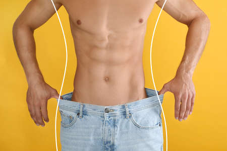 Closeup view of man with slim body in oversized jeans on yellow background. weight lossの写真素材