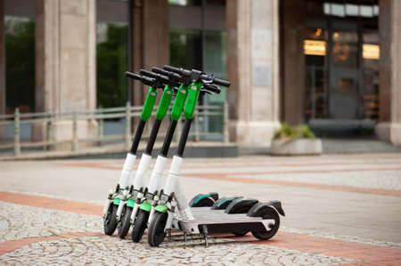 Row of electric scooters on city street. rental service
