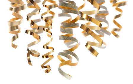Many golden serpentine streamers on white background. party decorの写真素材