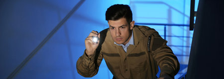 Professional security guard with flashlight on stairs in dark room. banner design