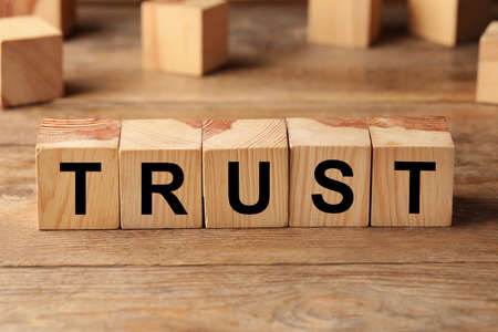 Cubes with word TRUST on wooden tableの写真素材