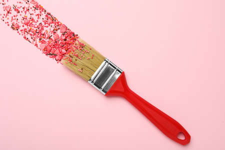 Brush painting with red sprinkles on pink background, top view. creative conceptの写真素材