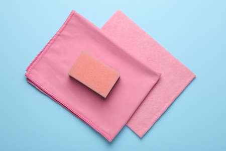 Sponge and rags on light blue background, top viewの写真素材