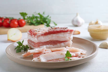 Tasty salt pork with parsley on white wooden tableの写真素材
